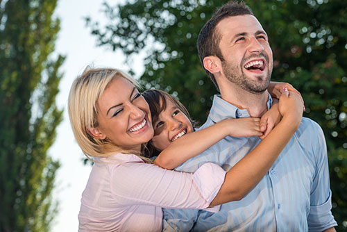 Laughing family hugging
